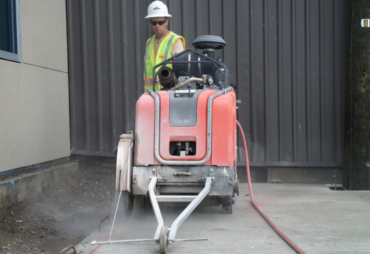 Marek operator in a hard hat and safety vest running a slab saw