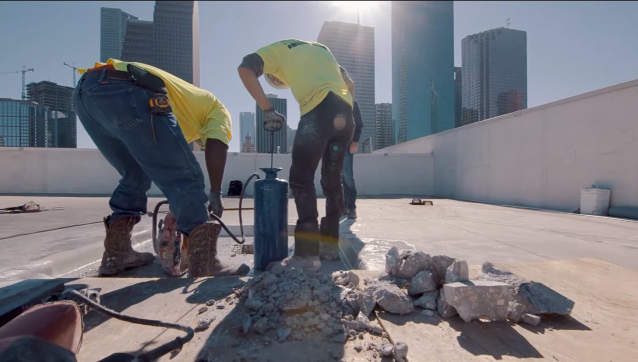 Marek crew members breaking concrete on a rooftop